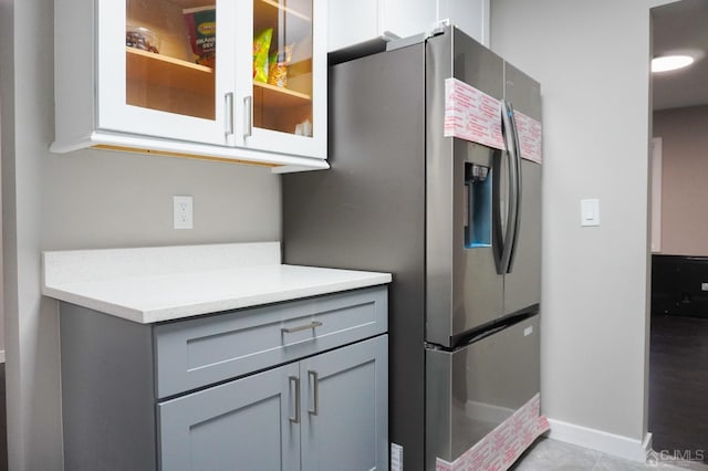 66 Willow Ave, Iselin, NJ 08830 - kitchen with stainless steel refrigerator with ice dispenser, gray cabinets, light countertops, glass insert cabinets, and baseboards