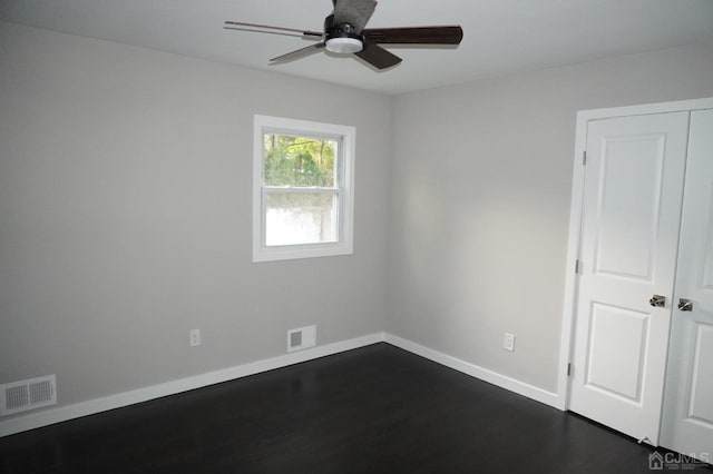 spare room featuring ceiling fan and dark hardwood / wood-style flooring