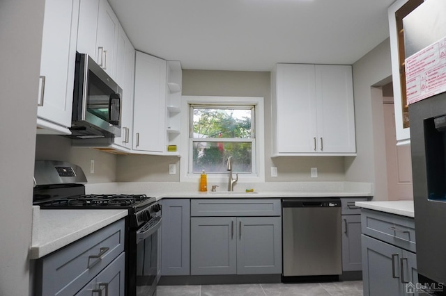 kitchen with gray cabinetry, white cabinets, and appliances with stainless steel finishes