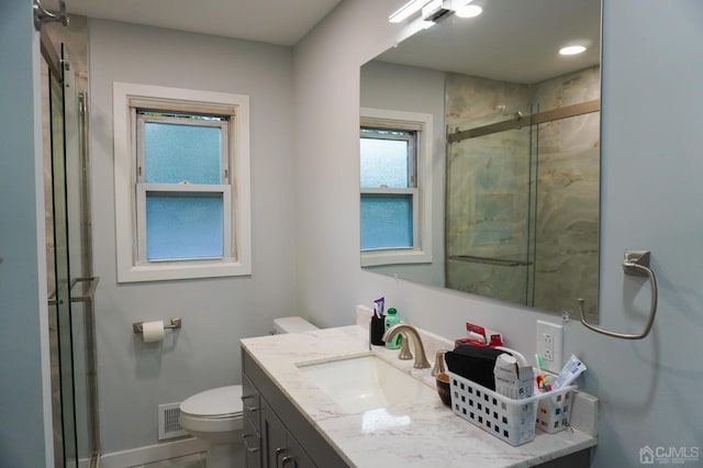 bathroom featuring vanity, toilet, and walk in shower