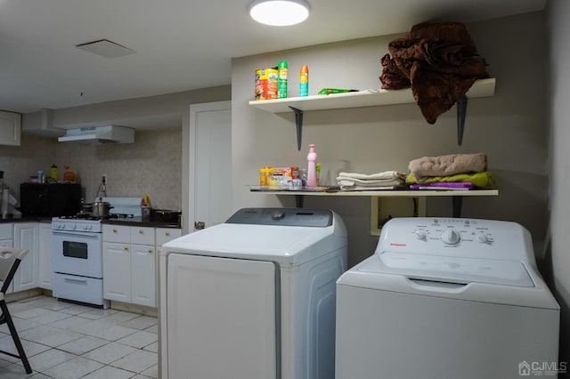 laundry area with separate washer and dryer and light tile patterned floors