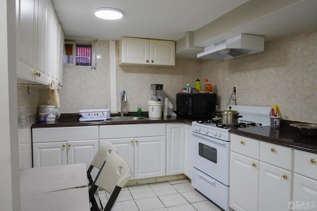 kitchen with ventilation hood, sink, white gas stove, light tile patterned flooring, and white cabinetry