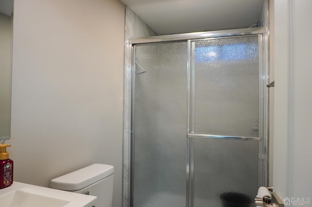 bathroom with vanity, a shower with shower door, and toilet