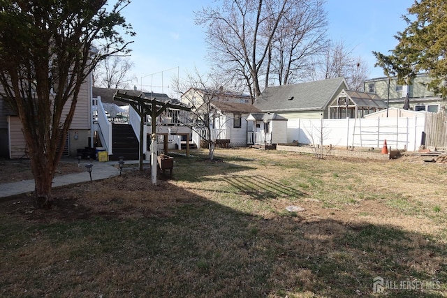 view of yard featuring stairs, an outbuilding, fence, and a wooden deck