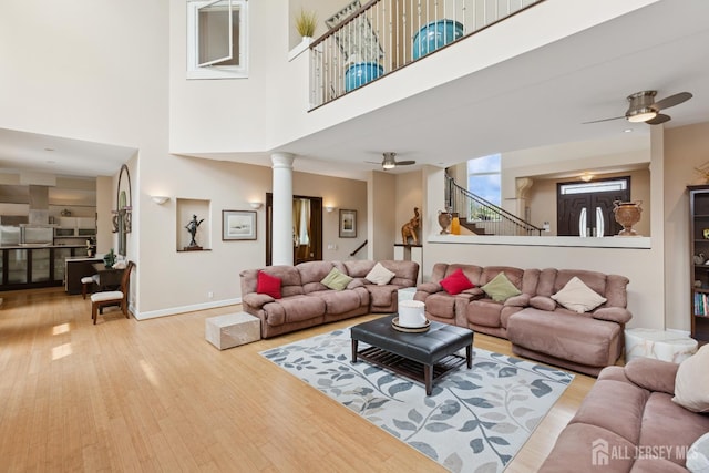 27 Mare Haven Ct, North Brunswick, NJ 08902 - living area featuring ceiling fan, wood finished floors, a towering ceiling, stairs, and ornate columns