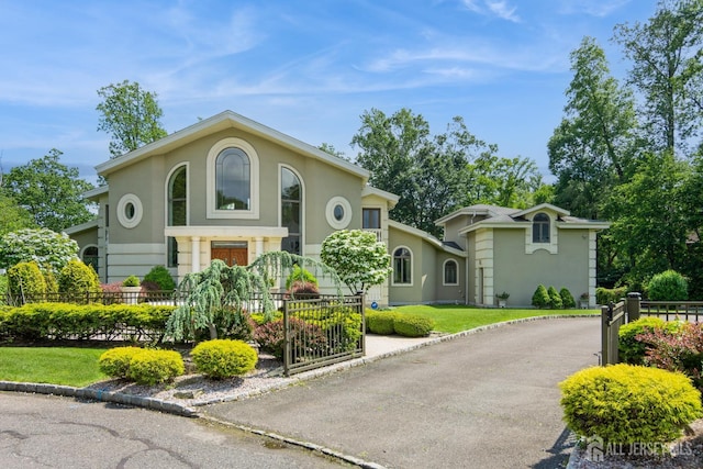 27 Mare Haven Ct, North Brunswick, NJ 08902 - mediterranean / spanish-style home with stucco siding, a fenced front yard, and driveway