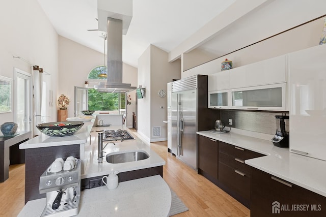 27 Mare Haven Ct, North Brunswick, NJ 08902 - kitchen featuring modern cabinets, island exhaust hood, vaulted ceiling, light countertops, and dark brown cabinetry
