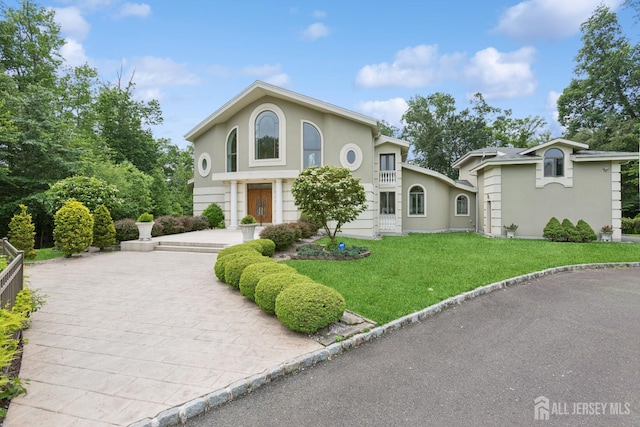27 Mare Haven Ct, North Brunswick, NJ 08902 - view of front of house featuring stucco siding, a front yard, and driveway