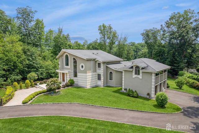 27 Mare Haven Ct, North Brunswick, NJ 08902 - view of front facade with asphalt driveway, an attached garage, stucco siding, a front lawn, and roof with shingles