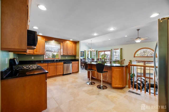 53 Rath Ln, East Brunswick, NJ 08816 - kitchen with stainless steel appliances, dark countertops, healthy amount of natural light, a kitchen bar, and recessed lighting