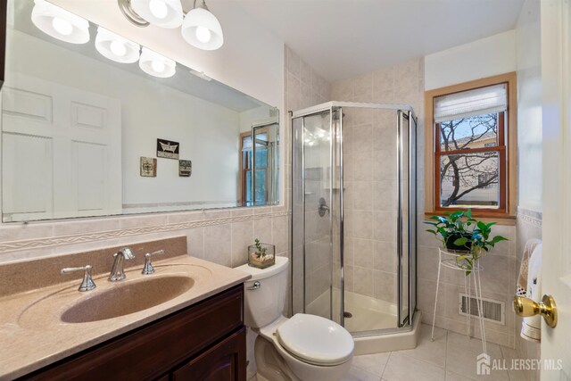 53 Rath Ln, East Brunswick, NJ 08816 - bathroom with tile walls, vanity, tile patterned floors, a stall shower, and a wainscoted wall
