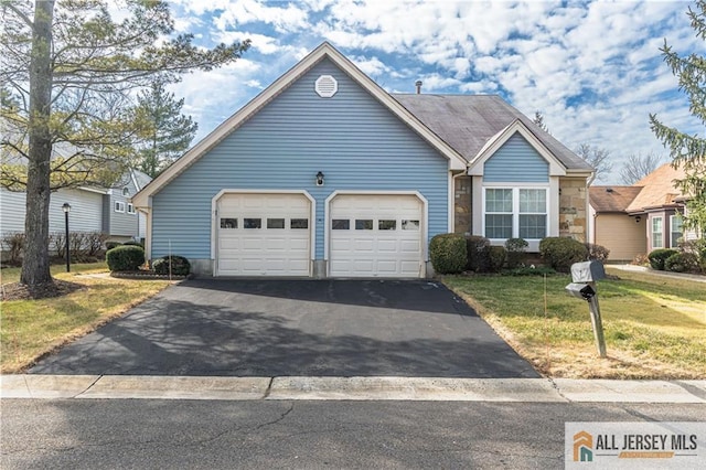 view of front facade featuring driveway, an attached garage, and a front lawn