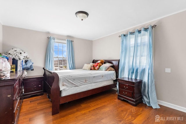 bedroom featuring baseboards and wood finished floors
