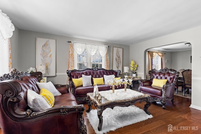living room with arched walkways and wood finished floors
