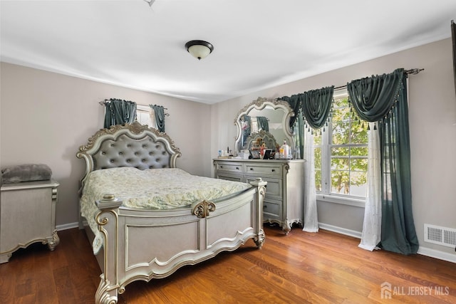 bedroom featuring dark wood-style flooring, baseboards, and visible vents