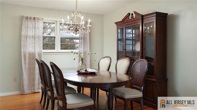 dining area with an inviting chandelier, baseboards, and light wood-style floors