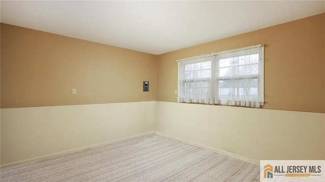 carpeted spare room featuring baseboards