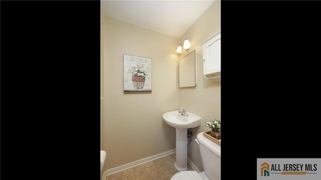 bathroom featuring toilet and baseboards