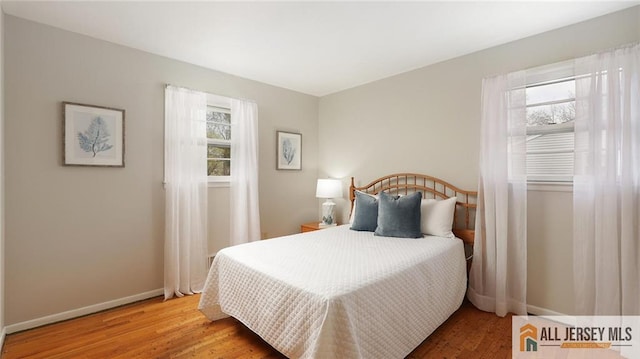 bedroom with baseboards and wood finished floors