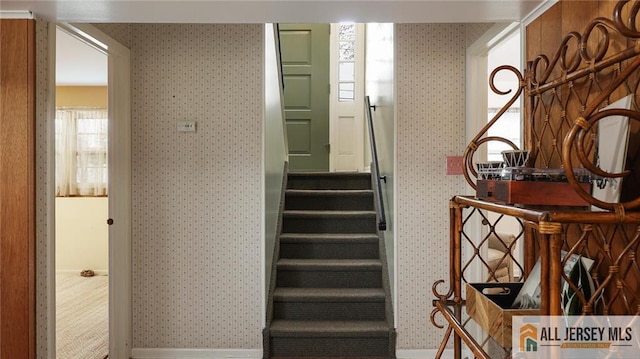 stairs featuring wallpapered walls