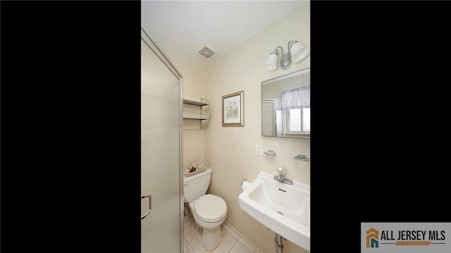 bathroom with toilet, tile patterned floors, visible vents, and a sink