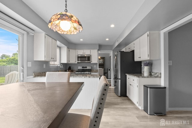 3 Mendon Ct, Howell, NJ 07731 - kitchen featuring appliances with stainless steel finishes, white cabinetry, light wood-type flooring, light stone counters, and pendant lighting