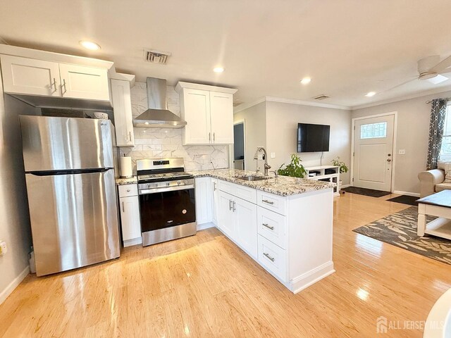 123 3rd St, Middlesex, NJ 08846 - kitchen with appliances with stainless steel finishes, wall chimney exhaust hood, a sink, crown molding, and a peninsula