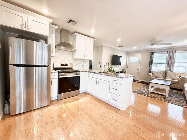 123 3rd St, Middlesex, NJ 08846 - kitchen with appliances with stainless steel finishes, wall chimney exhaust hood, open floor plan, a peninsula, and a sink