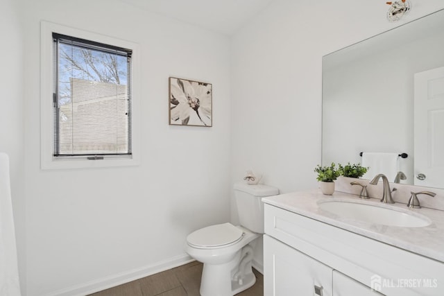 bathroom with baseboards, vanity, toilet, and wood finished floors