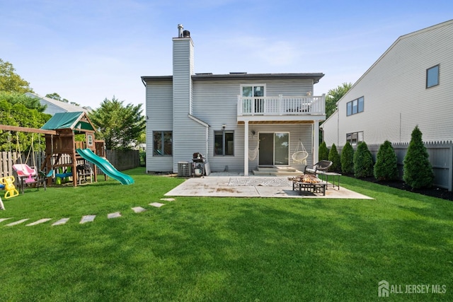 back of property featuring a yard, a patio area, a playground, and a fenced backyard