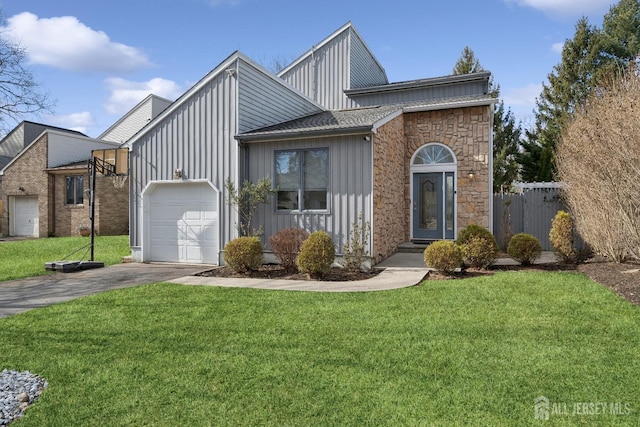 view of front of home featuring a garage, driveway, board and batten siding, and a front yard