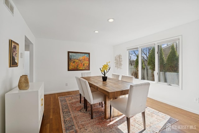 dining room with baseboards, wood finished floors, visible vents, and recessed lighting