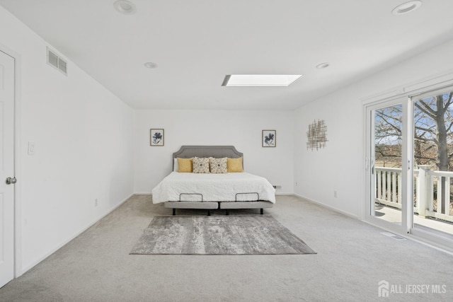 unfurnished bedroom with a skylight, baseboards, visible vents, access to exterior, and carpet flooring