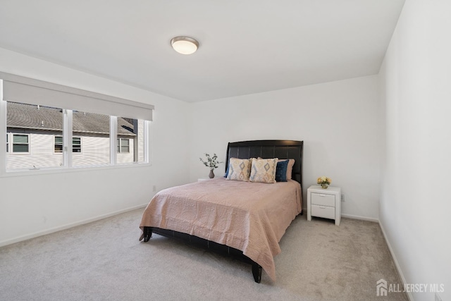 bedroom featuring light carpet and baseboards