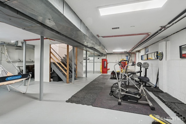 workout room featuring concrete block wall and visible vents