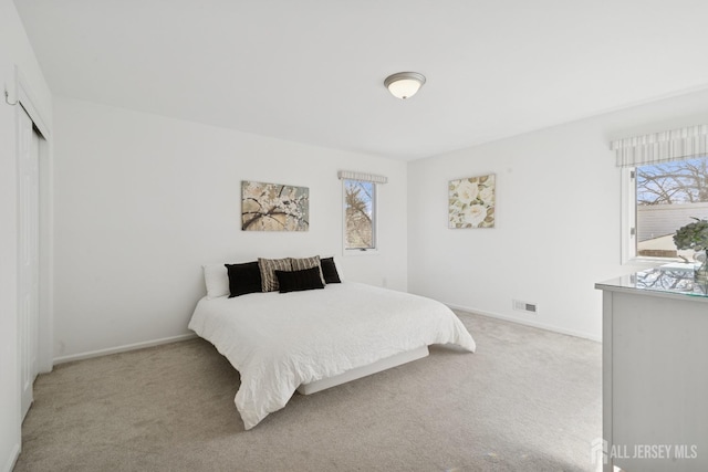 bedroom with carpet floors, visible vents, and baseboards