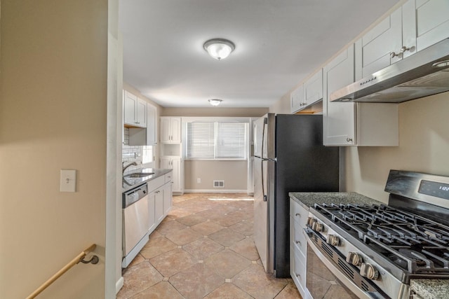 kitchen featuring under cabinet range hood, stainless steel appliances, a sink, visible vents, and white cabinetry