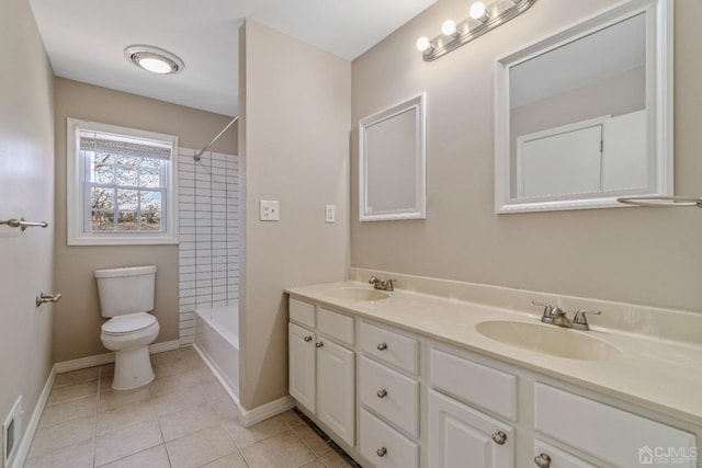 bathroom with double vanity, tile patterned flooring, toilet, and a sink