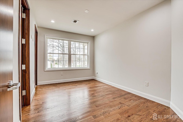spare room with baseboards, light wood-style flooring, visible vents, and recessed lighting