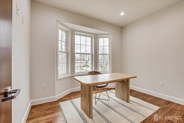 office space featuring light wood-type flooring, recessed lighting, and baseboards