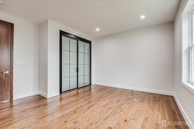 spare room with baseboards, recessed lighting, and light wood-style floors