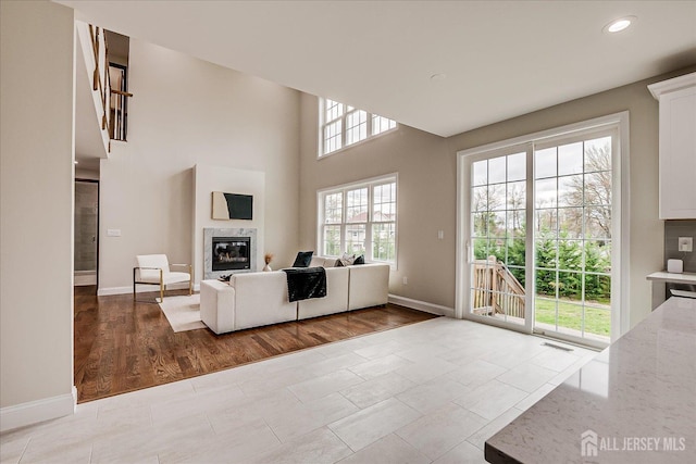 living room with wood finished floors, a fireplace, baseboards, visible vents, and recessed lighting