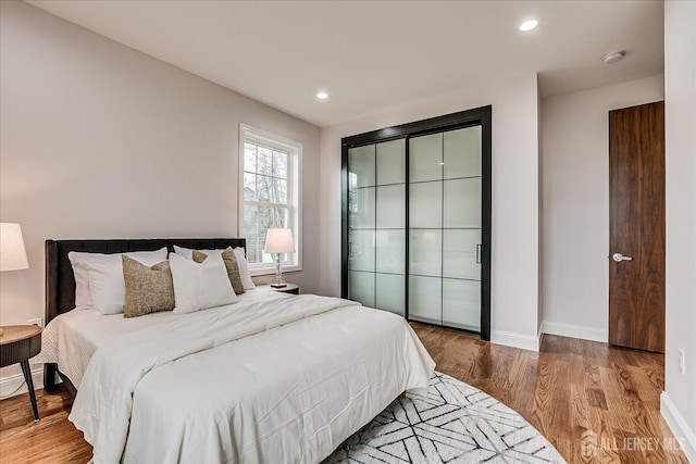 bedroom featuring recessed lighting, wood finished floors, and baseboards