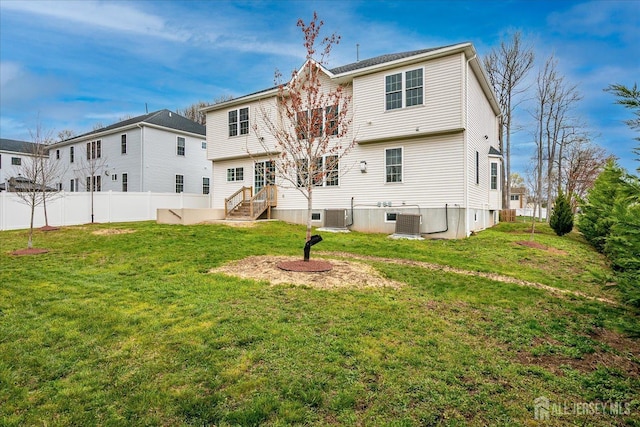 rear view of property with fence and a lawn