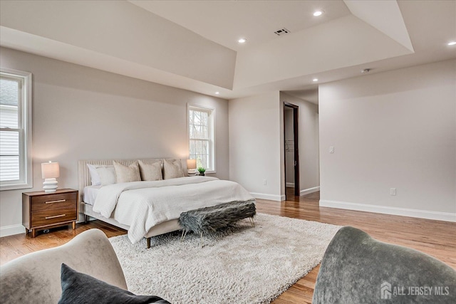 bedroom with light wood-type flooring, baseboards, recessed lighting, and visible vents