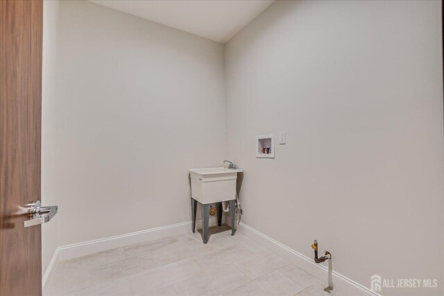 laundry area with light tile patterned flooring, hookup for a washing machine, laundry area, and baseboards