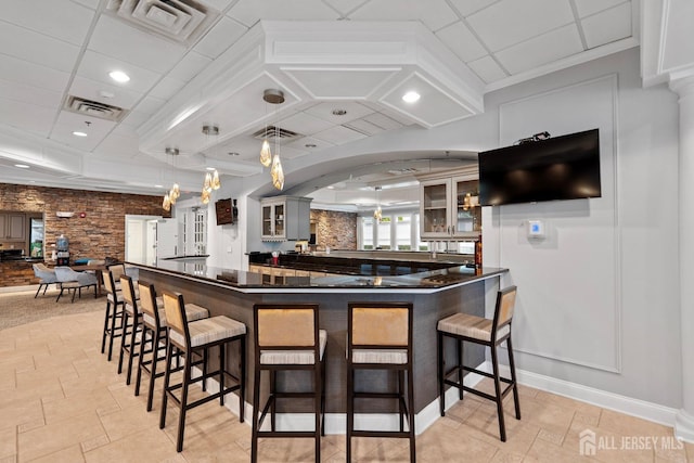 bar with pendant lighting, a community bar, visible vents, and arched walkways