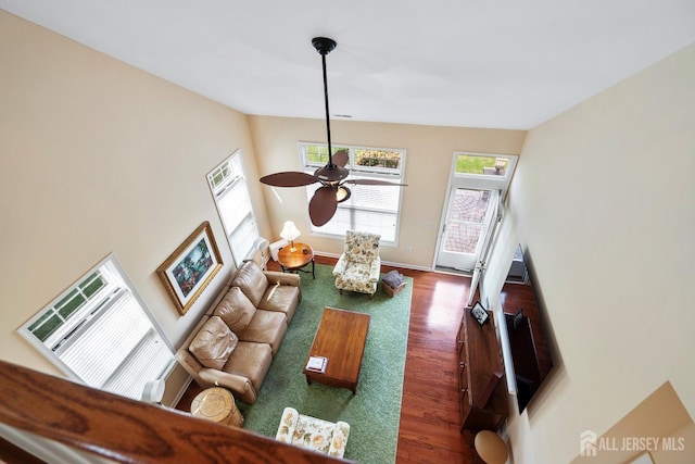 living room with an AC wall unit, ceiling fan, and wood finished floors