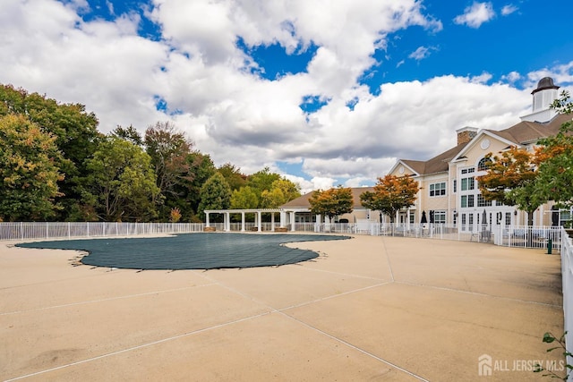 pool with a patio area and fence