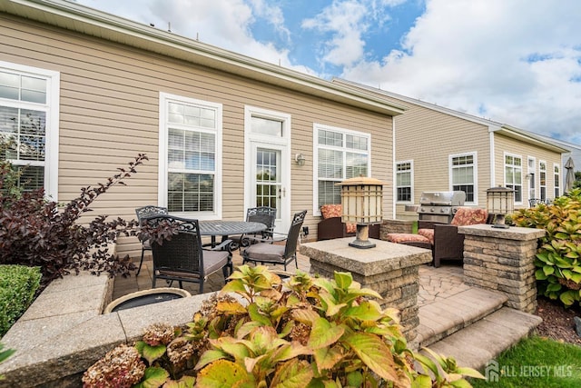 view of patio / terrace featuring outdoor dining space, area for grilling, and an outdoor kitchen